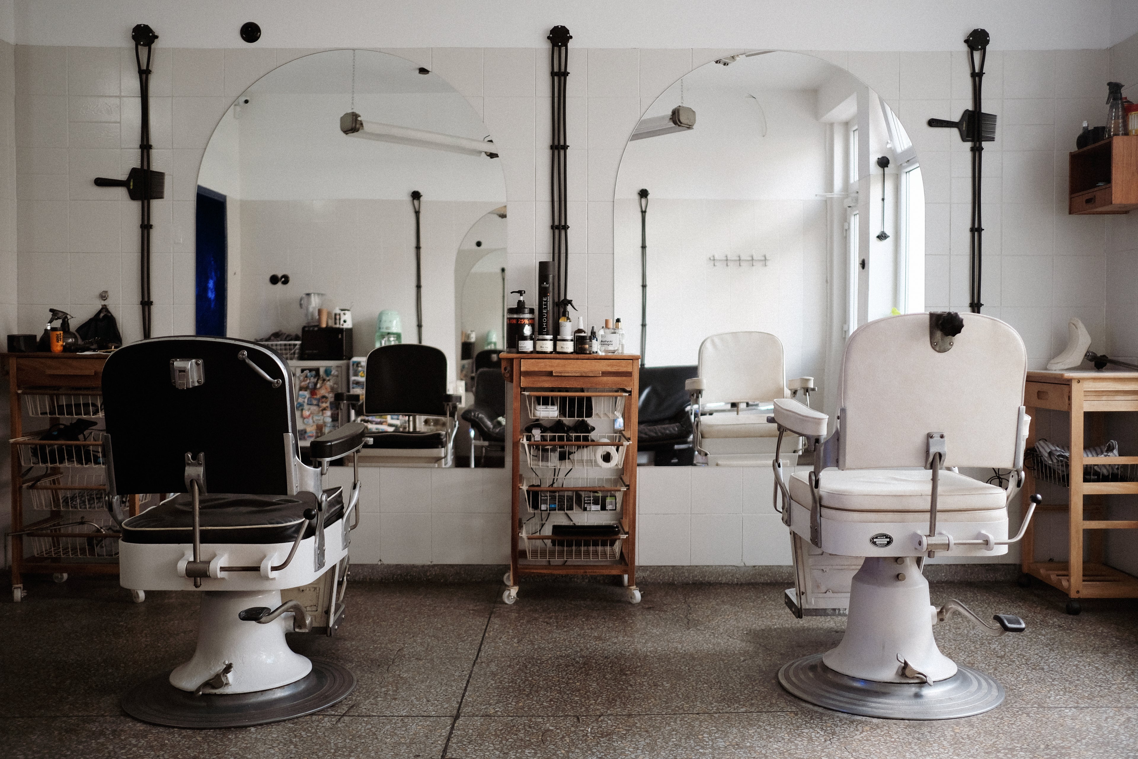 Salon barberski z dwoma fotelami i lustrami