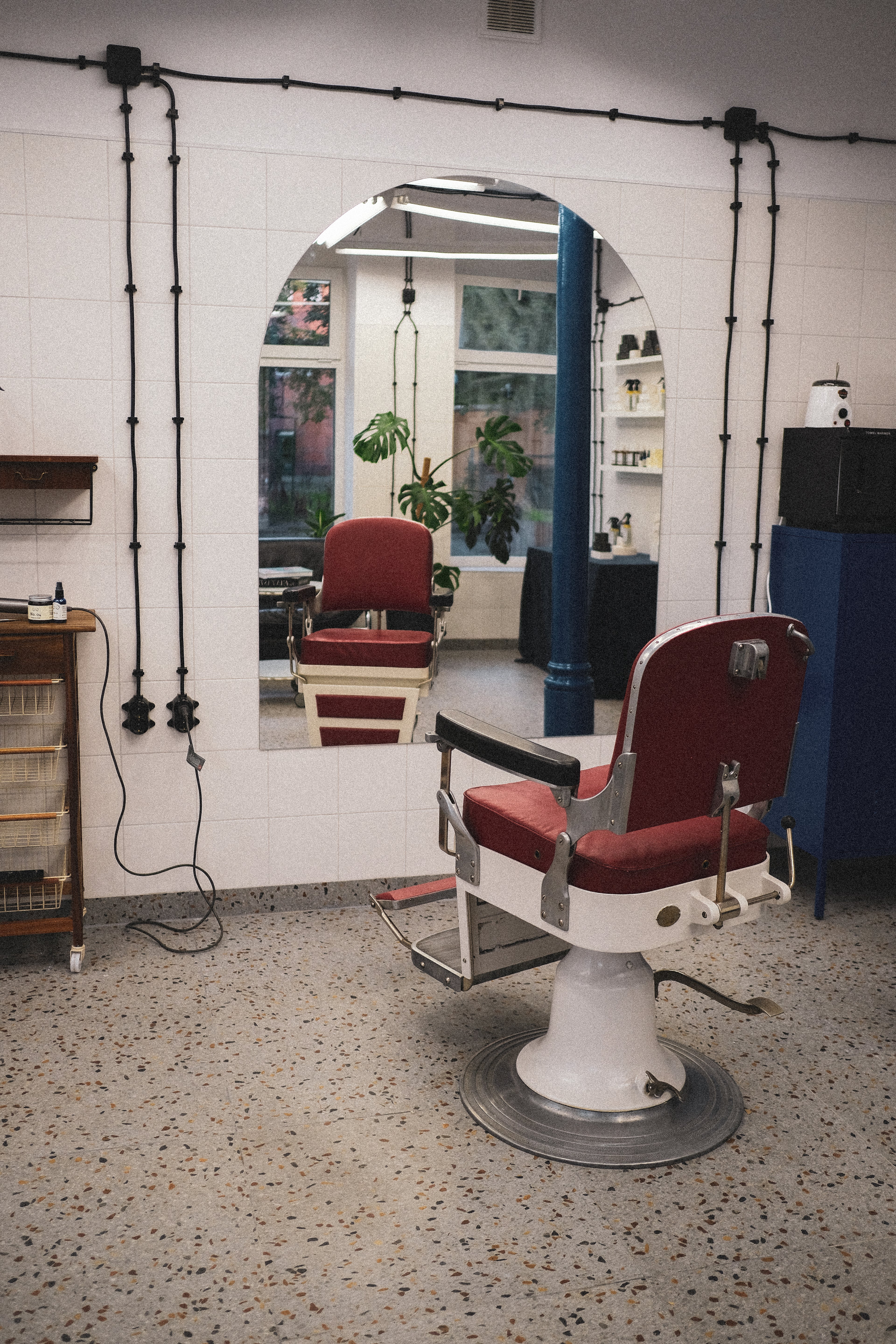 Salon barberski z czerwonym fotelem na przeciwko lustra